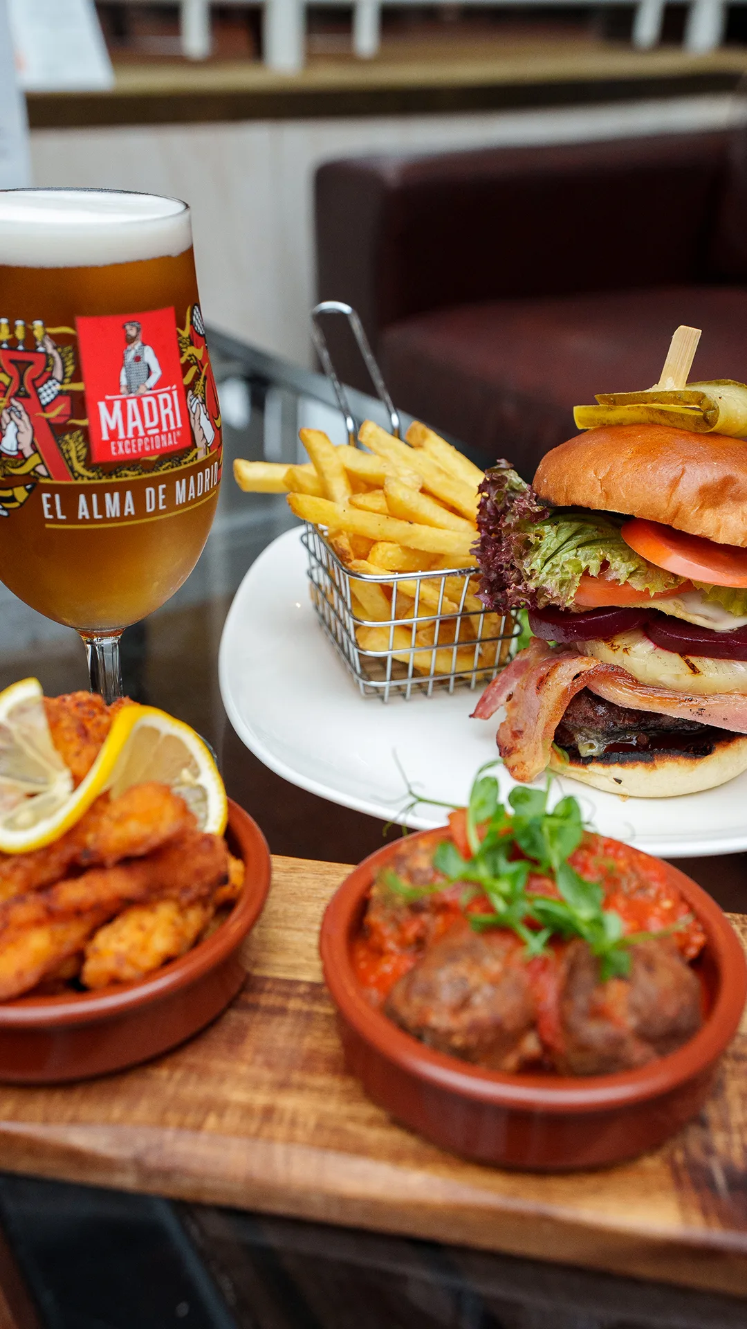 A selection of delicious nibbles, a juicy burger and fries, and a freshly poured beer. 